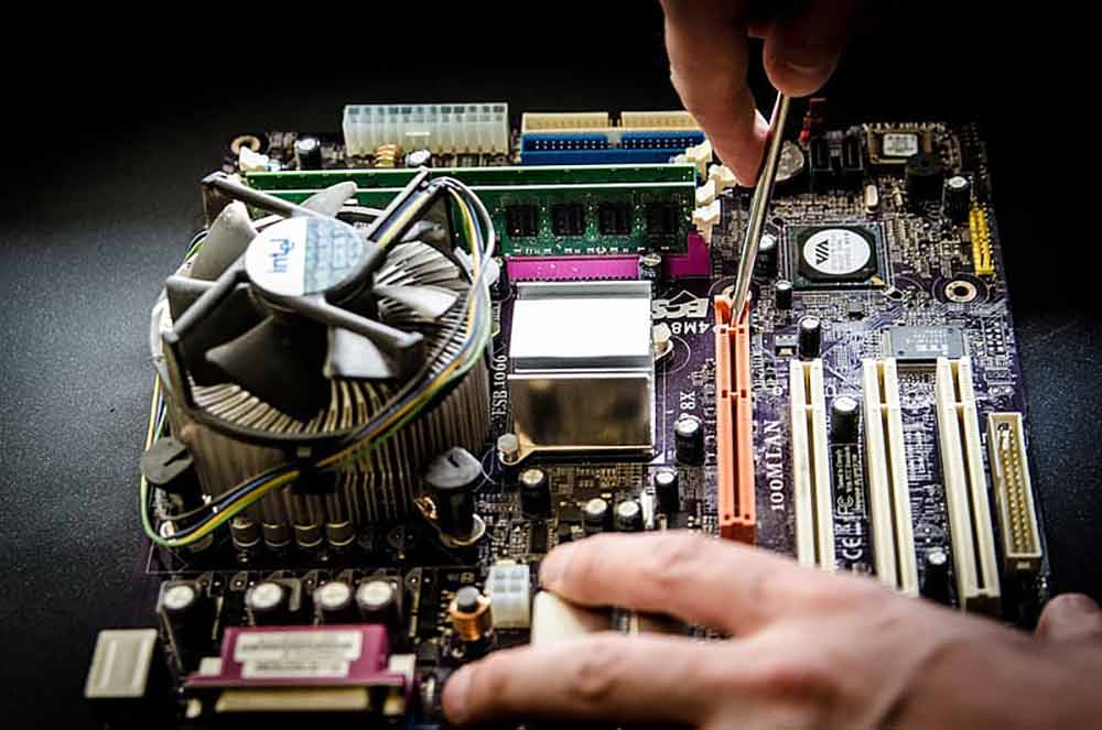 person-holding-screw-fixing-multicolored-computer-motherboard-low-res
